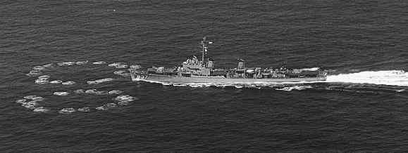 駆逐艦が左へ移動している。そのすぐ前方の水面には、小さな円形の波が2つ、進路の両側に広がっている。これらの波はほぼ真正面で交わっており、それぞれ直径は駆逐艦の長さの約半分である。