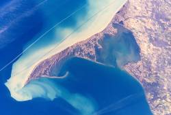 明るい堆積物の煙が上がるロング ポイント半島。(画像の上部は北ではなく南西を指しています。) 出典: NASA