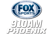 Fox Sports のロゴは、青い縁取りの銀色の楕円と青い文字の FOX Sports です。その下の 2 行の白い文字には、凝縮された斜体のサンセリフで「910 A M」と「Phoenix」が書かれています。