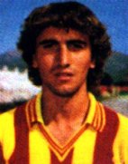 黄色と赤のストライプのジャージを着て、茶色の巻き毛の男性サッカー選手のビンテージ写真