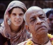 サリーを着た若い西洋人女性と、最前列にいるインド人スワミのカラー写真