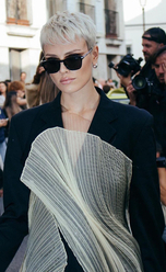 サングラスをかけ、銀色のブロンドのショートヘアで、デザイナージャケットを着たヨーロッパ出身の女性