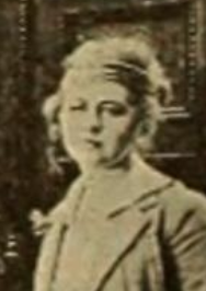 明るい色の髪を持ち、明るい色のジャケットを着た若い白人女性