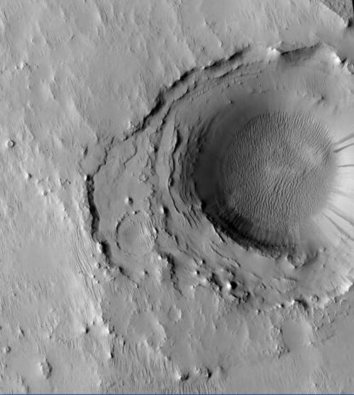 HiRISE が撮影したカッシーニの中央にあるクレーター。カッシーニにはかつて巨大な湖があったと考えられているため、層は水面下に堆積した可能性があります。