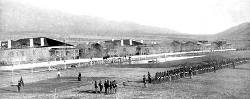 1885 年頃のアリゾナ州スタッフォード近郊のグラント砦の白黒写真。中央から右中央にかけて、4 個または 5 個中隊の兵士が隊列を組んで立っています。背景には砦の建物が見えます。