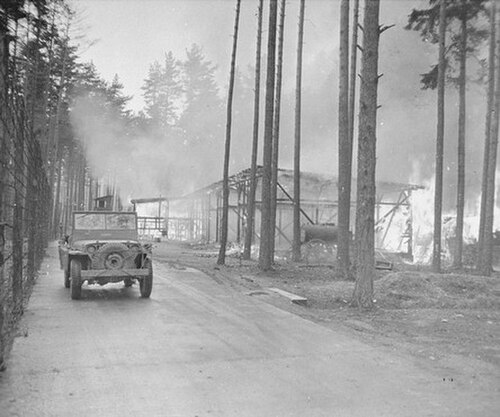アメリカ兵が、生存者たちが火を放った建物のそばを車で通り過ぎる。