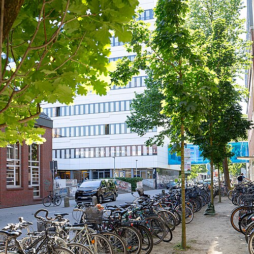 本館と学生食堂エリアの眺め。建物の前にはたくさんの自転車が停められている。