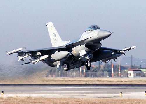 翼の下に武器を装備した重武装のジェット機が離陸します。