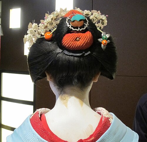 青い着物を着た舞妓さんを後ろから見たところ。