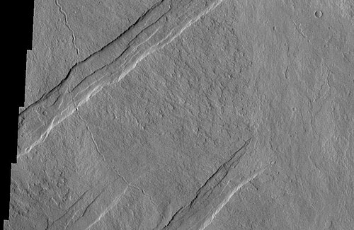 テミスが捉えたオティ・フォッサエ。これらの平行な地溝はアルシア山の北東側で発見され、タルシスの 3 つの火山の北東/南西方向の傾向と一致しています。