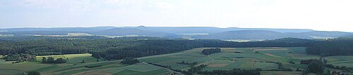 マロルツヴァイザッハ近郊のツァイルベルゲ東斜面から見たハスベルゲのなだらかな丘陵地帯。中央左：目立つ火山円錐丘、ブラムベルク。