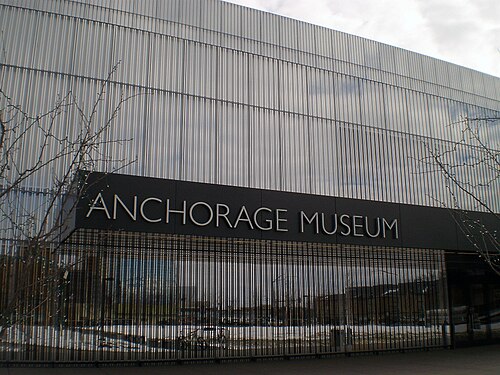 鏡張りの建物の正面には、「アンカレッジ博物館」と書かれたステンレス製の銘板が見える。