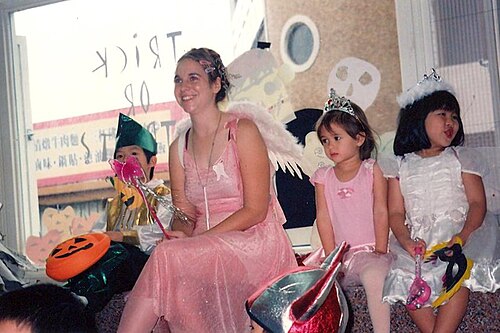 子供たちに囲まれた妖精の格好をした女性