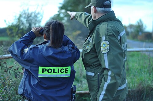 2016年以前の制服を着たケベック州警察の職員が、カナダ王立騎馬警察の警官と共に国境を監視している。