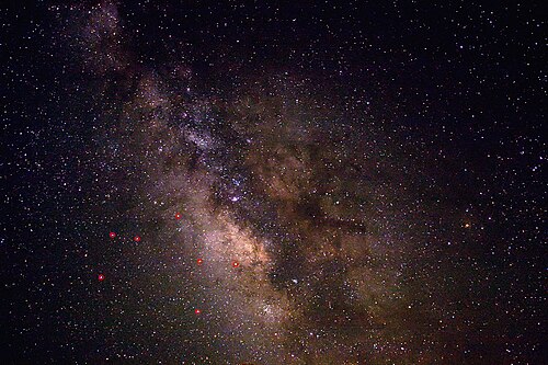 いて座付近の夜空の様子。コントラストと塵の帯のディテールをより鮮明にするために強調処理を施した画像です。いて座の主要な星は赤色で示されています。