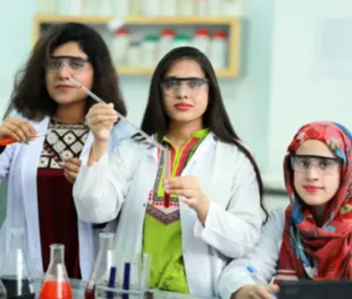 安全ゴーグルを着用して実習を行う女子薬学生たち。