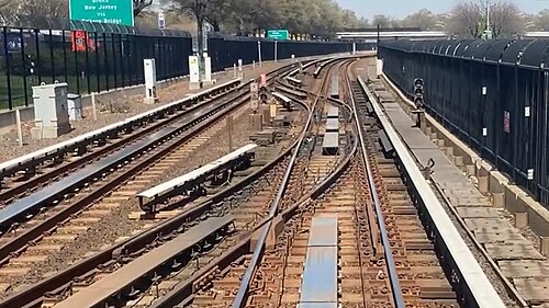 ヴァン・ウィック高速道路に沿って走る路線の区間。分岐器で接続された2本の線路がある。高速道路は左側、フェンスの向こう側にある。