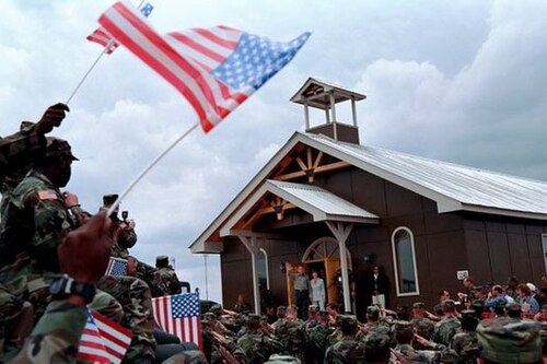 コソボのボンドスティール基地にある礼拝堂。大統領の訪問中の様子。礼拝堂の敷地内に後に建てられた仮設の十字架は撤去された。