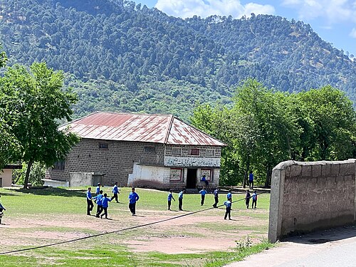 子供たちが高等中学校33番校のグラウンドでサッカーをしている。
