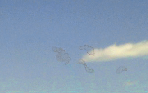 雲のある青空を背景に浮かぶ物体。