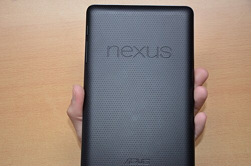 手に持った長方形のデバイスの背面の図。くぼんだ表面には、「Nexus」と「Asus」という 2 つの文字がはっきりと書かれています。