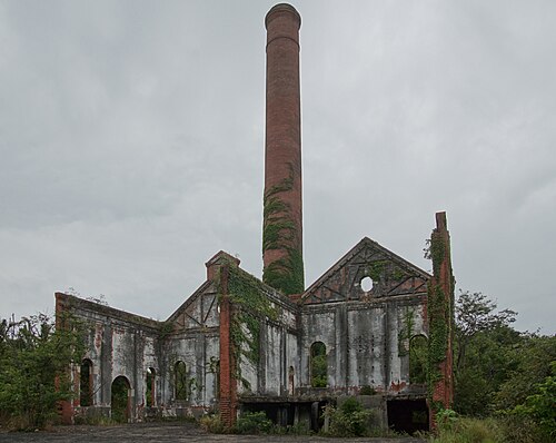 煙突の前には廃墟となった建物が立ち並び、煙突はゆっくりとツタに覆われつつある。