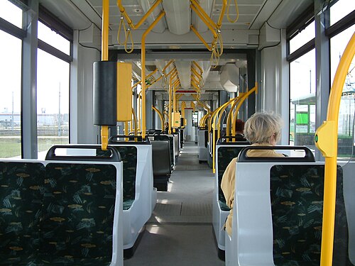 完全に平坦な路面電車の通路に沿った眺め。両側の座席は、シングルシートとペアシートが混在しています。