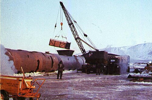 汚染された氷を大きな鋼鉄製タンクに積み込むクレーンの様子。