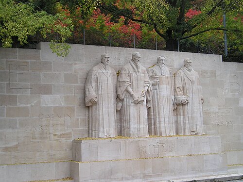 4人の髭を生やした男性の彫刻がある石の壁