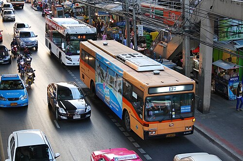 バス、車、タクシー、バイクなど多くの車両が走る道路の部分的な眺め