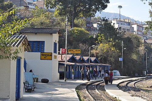 カーブの駅。プラットホームには人々が待っている