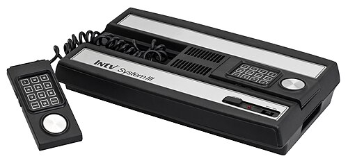 黒と銀のゲーム機。数字と円形のダイヤルが付いた2つのゲームパッド付き。