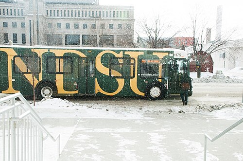 乗客がバスに乗り込む間、MATBUSの車両が雪の中で待機している。
