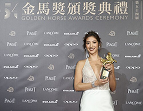 27歳のリマ・ゼイダンさんは、白いドレスを着て、2017年台北映画祭で最優秀新人俳優賞の金馬賞を手に持っています。