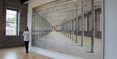 MASS MoCA で展示されている 8 x 15 フィートの絵画の前に立つバーバラ・プレイ