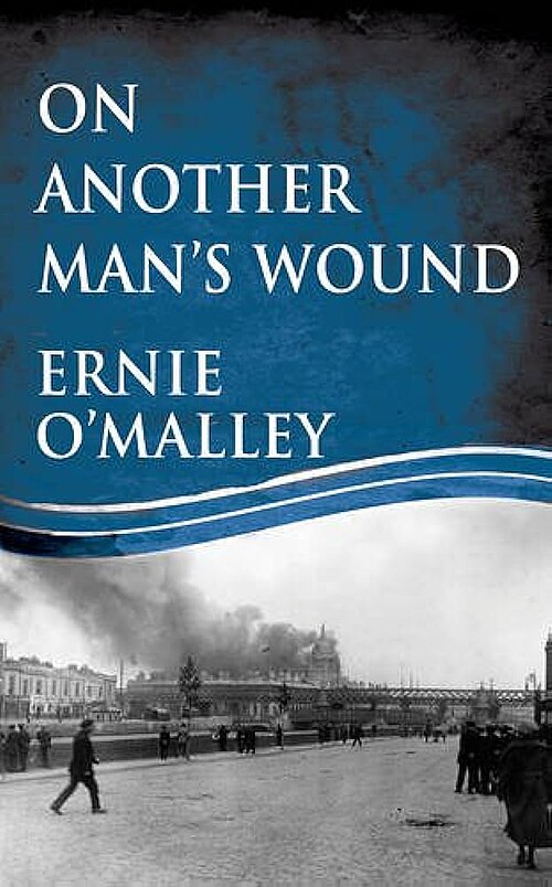 「アーニー・オマリー著『On Another Man's Wound』の表紙のカラー写真。橋の近くで火災が発生している建物の写真が写っている。」