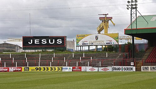 スタジアムの横にある黒い看板。白い文字で「JESUS」と書かれている。