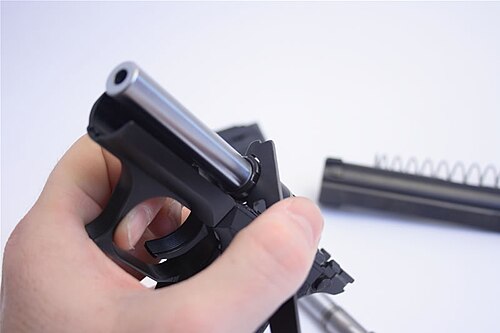 ヘッケラー＆コッホP7K3で、交換ツールを使用してバレルナットを締め付け、.32 ACPバレルを取り付けている。