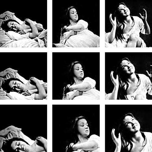 眠っている女性が微笑み、その後、真剣な表情で起き上がり、再び両手を上げて微笑む。