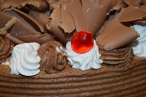 アイシングとホイップクリームを添えたチョコレートトリュフケーキ