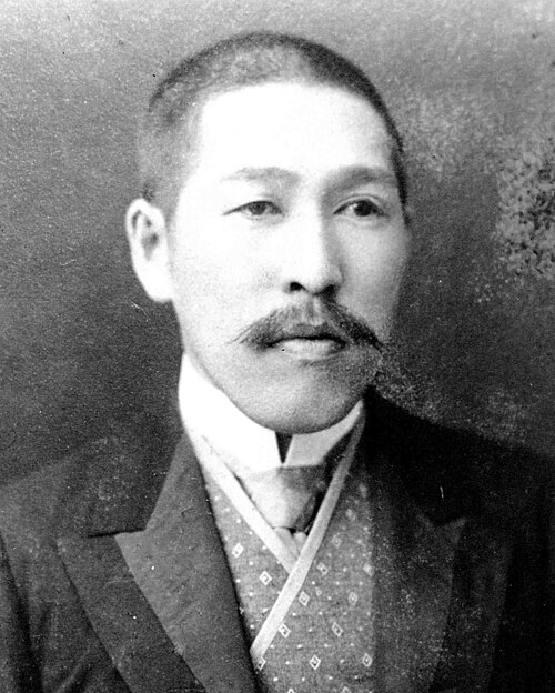 口ひげと短髪の日本人男性の白黒写真