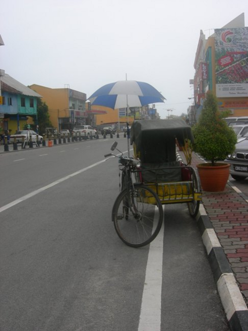 チュカイタウンを背景に、道端に駐車された三輪バイク。