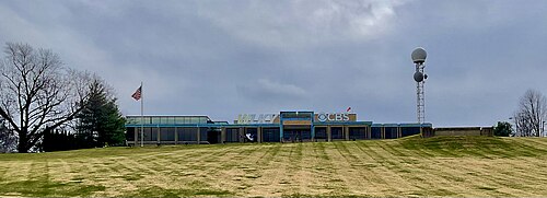 ケンタッキー州ルイビルにあるテレビ局WLKYの敷地内にある、傾斜したヘリポートの一例（右）。このヘリポートは、本来であればオハイオ川沿いの岸に向かって急勾配で下っている丘陵地に、ニュースヘリコプターが着陸できるように設計されている。