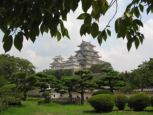 天守閣と眼下に広がる緑豊かな城の敷地の眺め