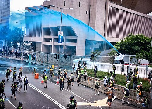 警察は抗議者を解散させ、身元を確認するために青色染料の放水砲を使用している