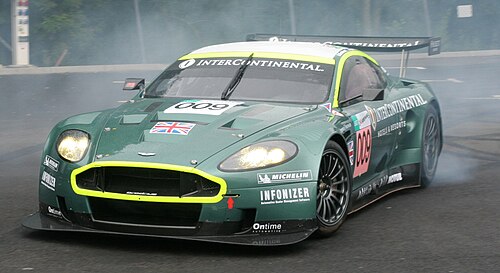 濃い緑色のレーシングカー、DBR9。派手なカラーリングが施されている。ドリフト走行中の姿が映し出されている。