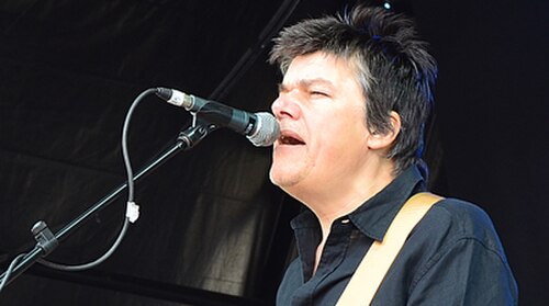 マイクに向かってライブ演奏するロバート博士のカラー写真。