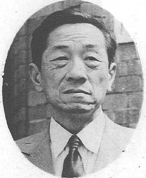 スーツとネクタイを着て正面を向いているアジア人男性。