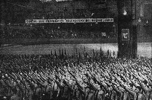 1943 年 4 月 11 日: パリのヴェルディヴで開かれたフランス革命戦線の集会。フランス レジスタンスと戦うために 1943 年 2 月 28 日に結成されたフランス ファシスト準軍事組織。この組織に積極的に協力していた警察はミリスと呼ばれ、上の写真の隊員たちはこの組織に忠誠を誓っている。(写真: ル マタン紙、1943 年 4 月 12 日)