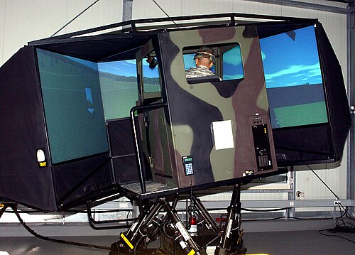 兵士が大型車両の運転シミュレーターを試している。